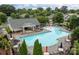 Community pool area surrounded by lounge chairs, umbrellas, and lush greenery at 308 Planters Way, Mount Holly, NC 28120