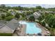 Aerial view of a community pool with lounge chairs and umbrellas surrounded by lush trees at 308 Planters Way, Mount Holly, NC 28120