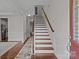 Elegant staircase with wood treads and white risers, enhancing the home's architectural appeal and charm at 308 Planters Way, Mount Holly, NC 28120