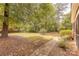 Lush backyard with mature trees and a stone pathway leading to a screened porch, creating a serene outdoor space at 3318 Providence Hills Dr, Matthews, NC 28105