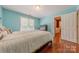 Bright bedroom featuring hardwood floors, a double window with blinds, and light blue painted walls at 3318 Providence Hills Dr, Matthews, NC 28105