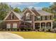 Stately brick home with manicured lawn, mature trees, and a welcoming front porch at 3318 Providence Hills Dr, Matthews, NC 28105