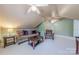 Attic living room with neutral carpet, vaulted ceilings and multiple ceiling fans at 3318 Providence Hills Dr, Matthews, NC 28105
