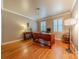 Home office with hardwood floors, large desk, shuttered windows and neutral color walls at 3318 Providence Hills Dr, Matthews, NC 28105