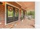 Charming front porch with brick floor, decorative wreaths, and comfortable seating area at 3318 Providence Hills Dr, Matthews, NC 28105