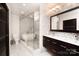 Modern bathroom featuring dual vanities, mosaic tile accent wall, a toilet, and a glass enclosed shower with a soaking tub at 333 W Trade St # 1304, Charlotte, NC 28202