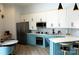 Modern kitchen features white and blue cabinetry, stainless steel appliances and an island with stool seating at 333 W Trade St # 1304, Charlotte, NC 28202