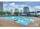 Upscale outdoor swimming pool with ample seating and lounge chairs in an urban setting surrounded by buildings at 333 W Trade St # 1304, Charlotte, NC 28202
