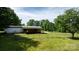 Fenced backyard with green grass and the rear of the house, in a wooded setting at 3423 S Hwy 127 Hwy, Hickory, NC 28602