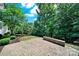 Spacious backyard showcasing a brick paver patio, mature trees, and manicured landscaping at 35115 Carnation Ln, Fort Mill, SC 29707