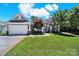 Charming home featuring well-manicured lawn, stone accents, and a two-car garage at 35115 Carnation Ln, Fort Mill, SC 29707