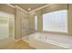 This bathroom features a glass-enclosed shower and a garden tub with tile floors at 35115 Carnation Ln, Fort Mill, SC 29707