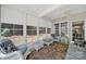 Bright sunroom with white wicker furniture, ceiling fans, and large windows with wooded view at 35115 Carnation Ln, Fort Mill, SC 29707