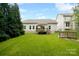 Large grassy backyard features a patio with an umbrella, landscaping, and fencing at 3807 Blazeprince Dr, Charlotte, NC 28215