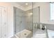 Glass-enclosed shower features modern fixtures, neutral tile and decor at 3807 Blazeprince Dr, Charlotte, NC 28215