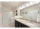Bright bathroom features a double sink vanity, granite countertops, and a glass-enclosed shower at 3807 Blazeprince Dr, Charlotte, NC 28215
