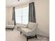 Bedroom featuring two sitting chairs, neutral-colored carpet, and window with gray curtains at 3807 Blazeprince Dr, Charlotte, NC 28215