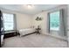 Cozy bedroom with natural light, features neutral carpet, decor, and an antique-style chest at 3807 Blazeprince Dr, Charlotte, NC 28215
