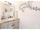 A clean half-bath is appointed with a modern mirror, stylish vanity, and decorative wall art at 3807 Blazeprince Dr, Charlotte, NC 28215