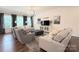 Spacious living room with comfortable seating, a decorative chandelier, and large windows at 3807 Blazeprince Dr, Charlotte, NC 28215