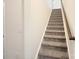 Carpeted staircase with a wooden handrail provides safe and elegant access to the upper floors at 3807 Blazeprince Dr, Charlotte, NC 28215