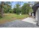 Great backyard with mature trees, privacy fence, gravel parking and patio area at 3900 Colebrook Rd, Charlotte, NC 28215