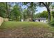 Spacious backyard featuring a lush lawn, mature trees, shed, and privacy fence; perfect for outdoor activities and relaxation at 3900 Colebrook Rd, Charlotte, NC 28215