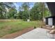 Spacious, fenced backyard with lush green grass, wood mulch, and patio seating at 3900 Colebrook Rd, Charlotte, NC 28215