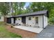 Charming home features updated exterior, cozy patio with seating and modern design at 3900 Colebrook Rd, Charlotte, NC 28215