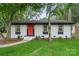 Charming single-story home with a bright red front door, white painted brick, and green lawn at 3900 Colebrook Rd, Charlotte, NC 28215