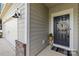 Close-up of the front door with wreath, neutral siding, and a carriage light for warm curb appeal at 3938 Isenhour Rd, Kannapolis, NC 28081