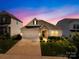 Charming home featuring manicured lawn, stone accents, and a two-car garage, set against a vibrant twilight sky at 3938 Isenhour Rd, Kannapolis, NC 28081