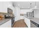 Modern kitchen with stainless steel appliances, gray countertops, white cabinetry, and stylish hardwood flooring at 3938 Isenhour Rd, Kannapolis, NC 28081