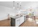 Bright, modern kitchen with quartz countertops and stainless steel appliances open to the living and dining spaces at 3938 Isenhour Rd, Kannapolis, NC 28081