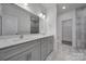 Bright bathroom features marble counters, double sinks, gray cabinetry, and walk-in shower at 4003 Rothwood Ln, Harrisburg, NC 28075