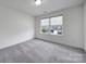 Well-lit bedroom featuring a large window offering natural light and neighborhood views at 4003 Rothwood Ln, Harrisburg, NC 28075