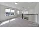Bright loft space features neutral carpet, dark wood trim, and three windows at 4003 Rothwood Ln, Harrisburg, NC 28075