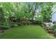 Lush backyard with synthetic turf, mature plants, and ample space for outdoor activities at 413 E Worthington Ave, Charlotte, NC 28203