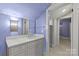 Charming bathroom with modern vanity, decorative lighting, and an open doorway to another room at 413 E Worthington Ave, Charlotte, NC 28203