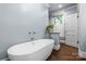 Modern bathroom featuring a freestanding tub and window with natural light and wood-look flooring at 413 E Worthington Ave, Charlotte, NC 28203