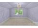Empty room filled with natural light features carpet and a chandelier at 413 E Worthington Ave, Charlotte, NC 28203