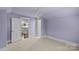 Empty room featuring natural light, and a chandelier with adjacent doors and carpet at 413 E Worthington Ave, Charlotte, NC 28203