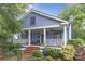 Charming blue two-story home with a inviting front porch, well-maintained garden, and a brick walkway at 413 E Worthington Ave, Charlotte, NC 28203