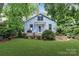 Charming home with blue siding, lush landscaping, and a well-maintained lawn at 413 E Worthington Ave, Charlotte, NC 28203