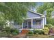 Charming blue two-story home featuring a welcoming front porch, landscaped yard, and a brick walkway at 413 E Worthington Ave, Charlotte, NC 28203