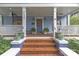 Inviting front porch with brick steps, plants, and cozy seating, perfect for relaxing outdoors at 413 E Worthington Ave, Charlotte, NC 28203