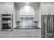 Stylish kitchen with stainless steel appliances, light blue backsplash, and modern fixtures at 413 E Worthington Ave, Charlotte, NC 28203