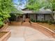 Inviting exterior showcases brick accents, mature trees, and a concrete driveway leading to the entrance at 449 Windward Dr, Davidson, NC 28036