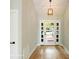 Hallway with hardwood floors and pendant lighting, leading to a set of glass paneled entry doors at 449 Windward Dr, Davidson, NC 28036