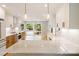 Bright, modern kitchen with white cabinets, a large marble island, stainless appliances, and natural wood flooring at 449 Windward Dr, Davidson, NC 28036